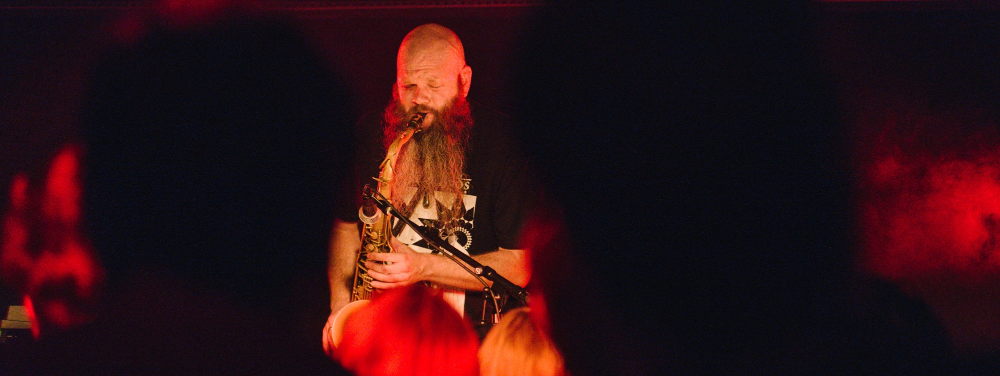 Adam Page performing saxophone on stage